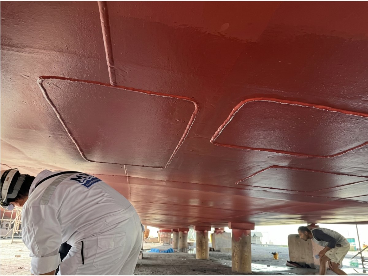 Surveyors inspecting the underside of a hull