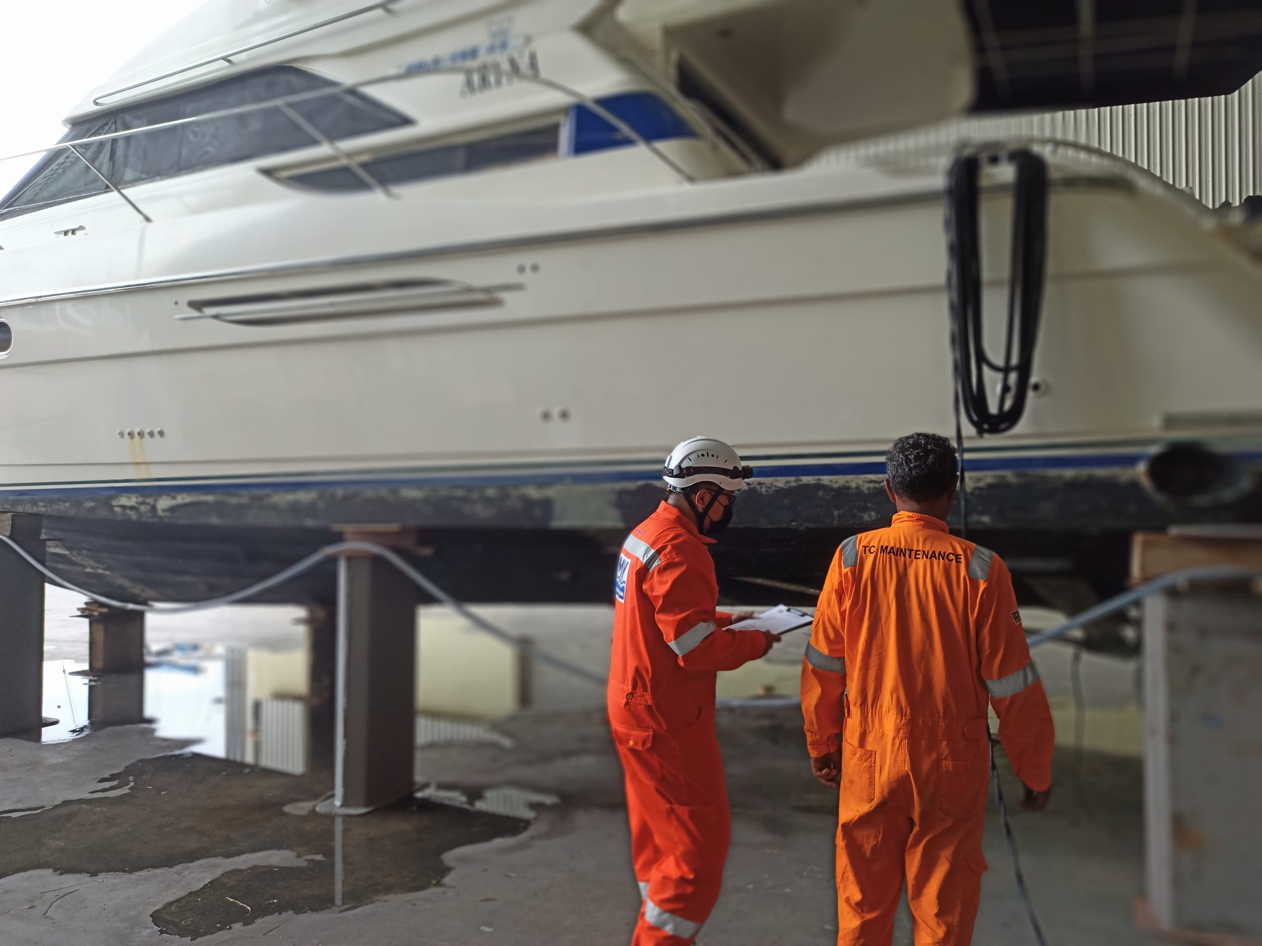 Surveyors inspecting the underside of a hull